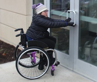 Greenberg demonstrating how to open a non-handicap accessible door